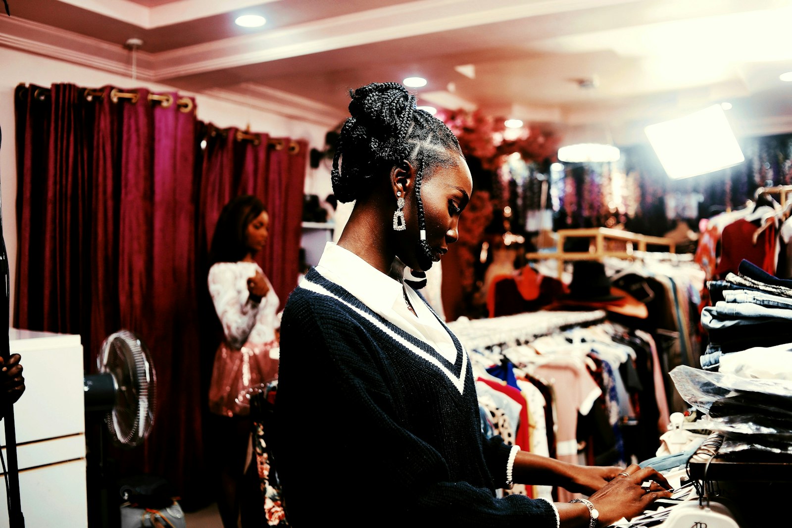 Boutique owner using her phone among clothing racks